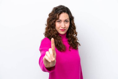 Beyaz arka planda izole edilmiş genç beyaz kadın parmağını kaldırıyor ve gösteriyor.