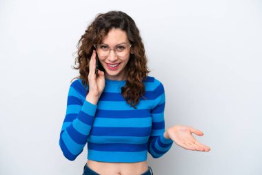 Beyaz arka planda izole edilmiş genç beyaz bir kadın cep telefonuyla sohbet ediyor.