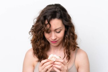 Beyaz arka planda izole edilmiş beyaz bir kadın elinde mutlu bir ifadeyle çiçekleri tutuyor. Portreyi kapat