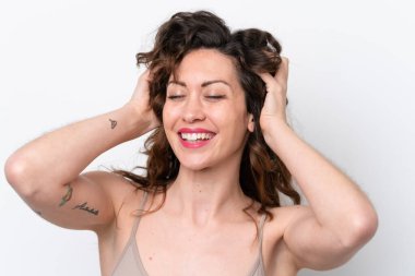 Beyaz arka planda izole edilmiş genç beyaz kadın saçlarına dokunuyor. Portreyi kapat