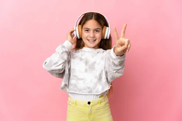 子供以上隔離されたピンクの背景リスニング音楽と歌 — ストック写真
