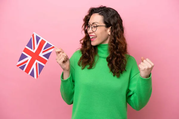 Mladá Běloška Drží Anglickou Vlajku Izolované Růžovém Pozadí Slaví Vítězství — Stock fotografie