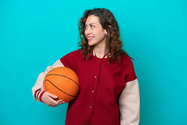 若いです白人バスケットボール選手女性隔離された上に青の背景を見ます側と笑顔 — ストック写真