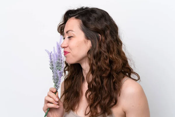 stock image Young caucasian woman isolated on white background holding a lavender plant. Close up portrait