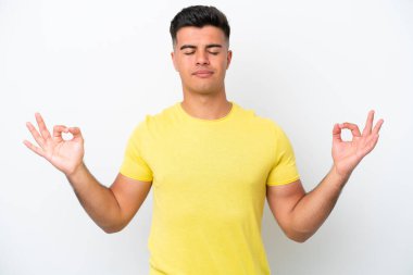 Beyaz arka planda Zen pozisyonunda beyaz tenli yakışıklı bir adam.
