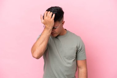 Pembe arka planda yalnız ve başı ağrıyan beyaz, yakışıklı genç bir adam.