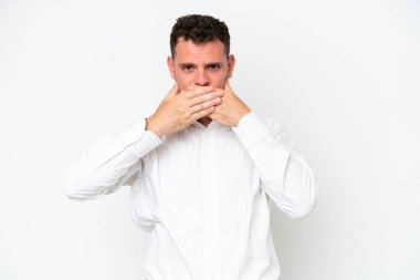 Beyaz arka planda izole edilmiş beyaz tenli yakışıklı bir adam elleriyle ağzını kapatıyor.