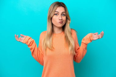 Genç Uruguaylı kadın mavi arka planda izole edilmiş.