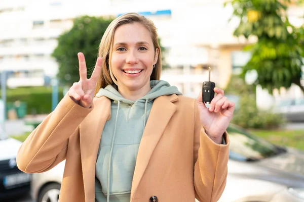 Νεαρή Ξανθιά Γυναίκα Κρατώντας Κλειδιά Του Αυτοκινήτου Εξωτερικούς Χώρους Χαμογελώντας — Φωτογραφία Αρχείου