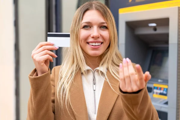 Młoda Ładna Blondynka Trzymająca Kartę Kredytową Świeżym Powietrzu Zapraszająca Wyjścia — Zdjęcie stockowe