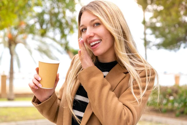 Jovem Mulher Loira Bonita Segurando Tomar Café Livre Sussurrando Algo — Fotografia de Stock