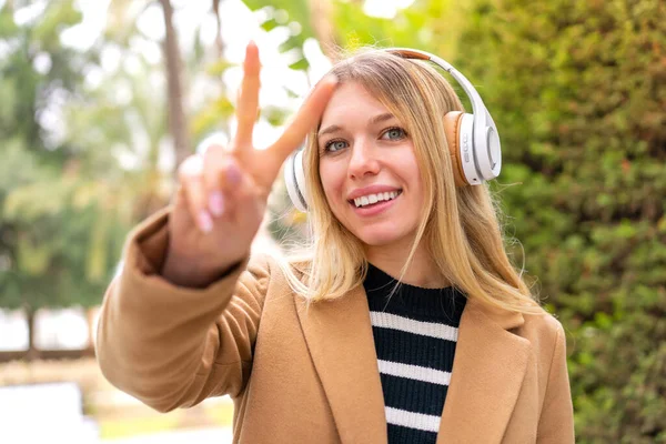 Joven Mujer Rubia Bonita Escuchando Música Con Auriculares Aire Libre —  Fotos de Stock