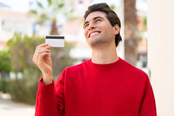 Young Handsome Man Holding Credit Card Outdoors Looking While Smiling — Stock Photo, Image