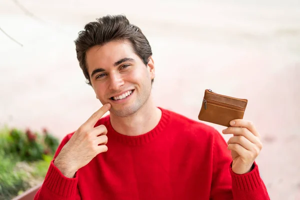 Молодой Красивый Мужчина Держит Бумажник Счастливым Выражением Лица — стоковое фото