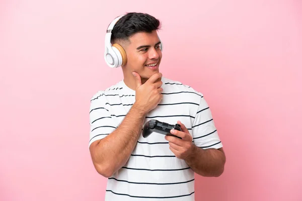 Молодой Красивый Мужчина Играет Контроллером Видеоигры Изолированы Розовом Фоне Глядя — стоковое фото