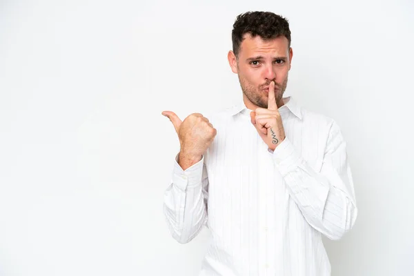 stock image Young caucasian handsome man isolated on white background pointing to the side and doing silence gesture