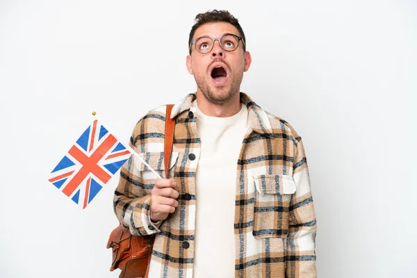 年轻而惊慌的男子举着一面英国国旗 背景是白色的 他抬起头 满脸惊讶地看着 — 图库照片