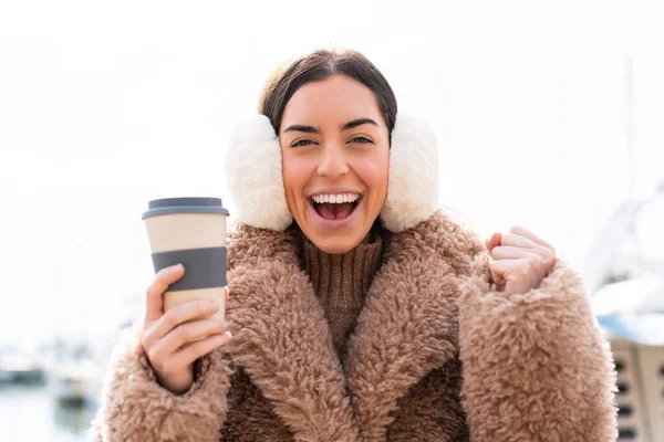 Młoda Kobieta Ubrana Zimowe Kajdanki Trzymająca Kawę Świeżym Powietrzu Wstrząśniętym — Zdjęcie stockowe