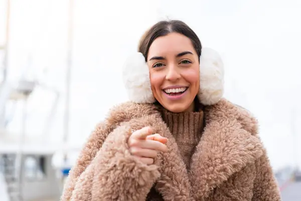 Young Woman Wearing Winter Muffs Outdoors Surprised Pointing Front — Stock Photo, Image