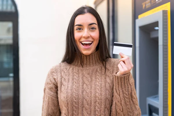 Młoda Kobieta Trzymająca Kartę Kredytową Świeżym Powietrzu Zaskoczeniem Wstrząśniętym Wyrazem — Zdjęcie stockowe