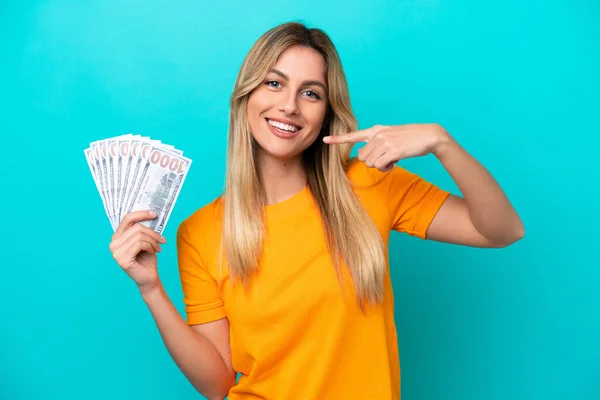 Young Uruguayan Woman Taking Lot Money Isolated Blue Background Giving — Stock Photo, Image