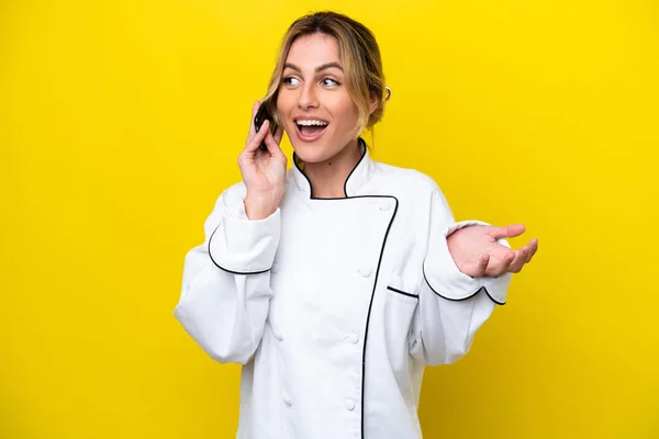 Chef Uruguayo Mujer Aislada Sobre Fondo Amarillo Manteniendo Una Conversación —  Fotos de Stock