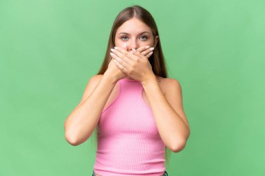 Genç, güzel sarışın kadın izole edilmiş arka planda elleri ağızla örtüyor.