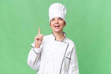 Genç aşçı kadın izole edilmiş yeşil arka plan 