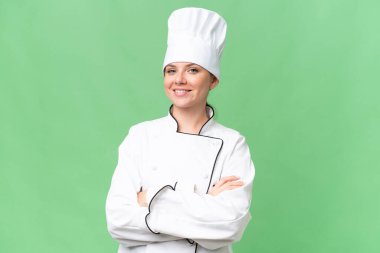 Genç aşçı kadın izole edilmiş yeşil arka plan 