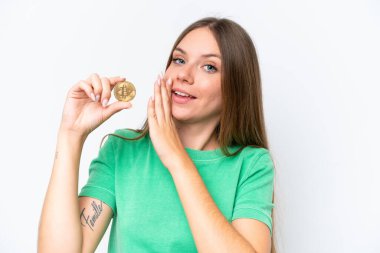 Beyaz arka planda izole edilmiş Bitcoin tutan güzel sarışın kadın bir şeyler fısıldıyor.