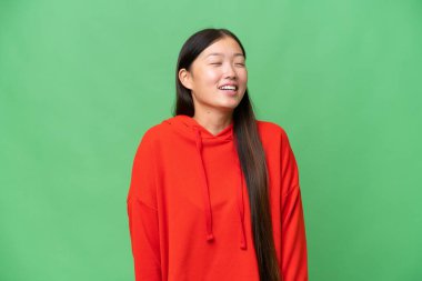 Asyalı genç bir kadın, izole edilmiş arka planda bir ilan vermek için avucunun içinde hayali bir mekan tutuyor.