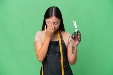 Genç Asyalı terzi kadın, izole edilmiş, yorgun ve hasta bir yüz ifadesi var.