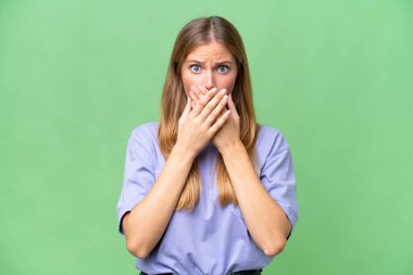 İzole edilmiş arka planda genç ve güzel bir kadın elleriyle ağzını kapatıyor.