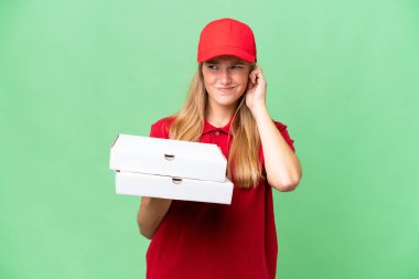 İş üniformalı beyaz pizza dağıtan kadın izole edilmiş arka planda pizza kutularını topluyor hayal kırıklığına uğramış ve kulaklarını kapatıyor.