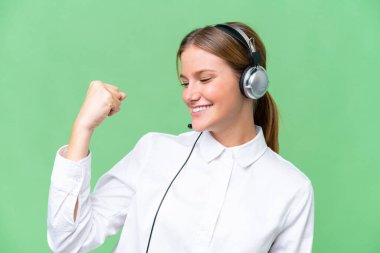 Tele pazarlamacı Kafkas kadın tecrit edilmiş arka planda bir kulaklıkla zaferi kutluyor.