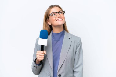 Young TV presenter caucasian woman isolated on white background looking up while smiling clipart