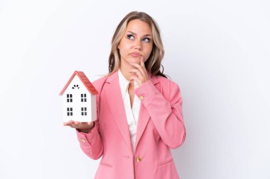 Rus emlakçı, beyaz arka planda izole edilmiş bir oyuncak evi tutuyor.