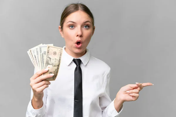 Νεαρή Γυναίκα Καυκάσιος Επιχειρηματίας Που Κρατάει Χρήματα Απομονωμένο Υπόβαθρο Έκπληκτος — Φωτογραφία Αρχείου