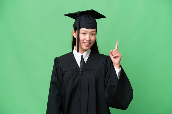 졸업생 아시아 여자가 배경에서 최고의 신호로 손가락을 손가락을 들었다 — 스톡 사진