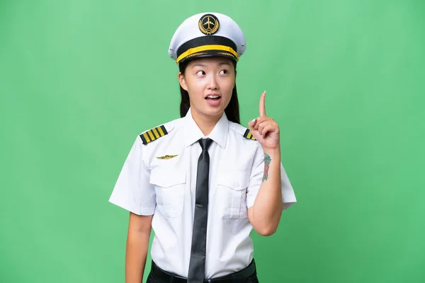飞机驾驶员亚洲女人在孤立的背景下思考着一个指指点点的想法 — 图库照片