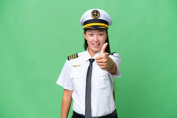 由于发生了一些好事 飞机驾驶员亚洲女人竖起大拇指 克服了孤立的背景 — 图库照片
