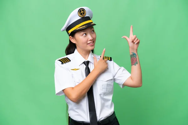 飞机驾驶员亚洲女人克服孤立的背景 用食指指指点点是个好主意 — 图库照片