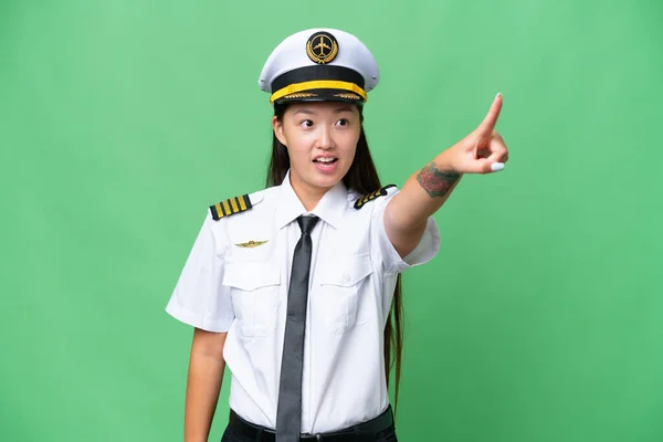 飞机驾驶员亚洲妇女在孤立的背景下指指点点 — 图库照片