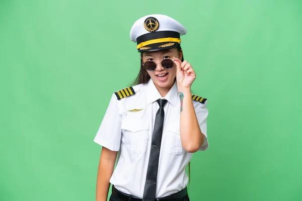 飞机驾驶员亚洲女人克服孤立的背景与眼镜和惊讶 — 图库照片