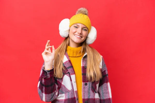 Νεαρή Όμορφη Γυναίκα Φορώντας Muffs Χειμώνα Απομονώνονται Κόκκινο Φόντο Χαιρετισμό — Φωτογραφία Αρχείου