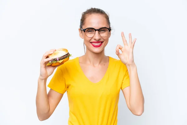 Young Caucasian Woman Holding Burger Isolated White Background Showing Sign — Zdjęcie stockowe