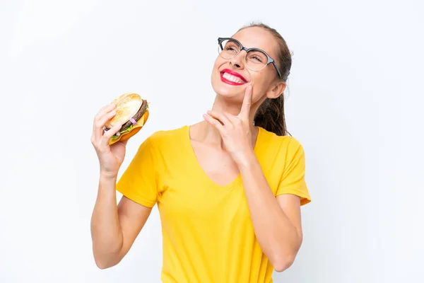 Jeune Femme Caucasienne Tenant Hamburger Isolé Sur Fond Blanc Pensant — Photo