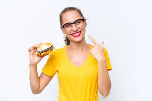 Young Caucasian Woman Holding Burger Isolated White Background Giving Thumbs — Zdjęcie stockowe