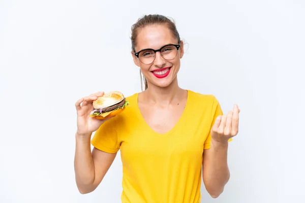 Młoda Kaukaska Kobieta Trzyma Hamburgera Odizolowany Białym Tle Pieniądze Gest — Zdjęcie stockowe