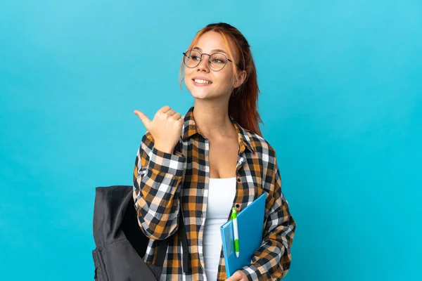 Tiener Student Russisch Meisje Geïsoleerd Blauwe Achtergrond Wijzend Naar Zijkant — Stockfoto